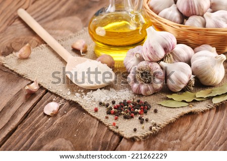 garlic, sea salt, pepper, sunflower oil, bay leaf, against a background of burlap and wooden planks