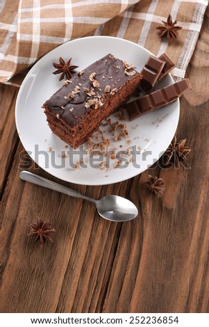 chocolate cake and chocolate in a bowl on a wooden boards background