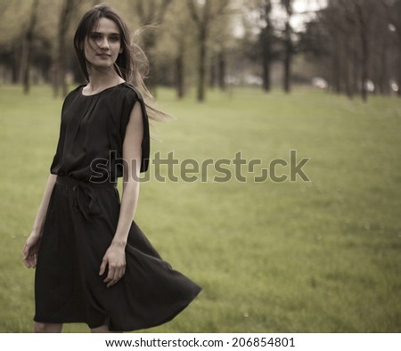 Romantic beautiful girl wearing a black dress in the forest