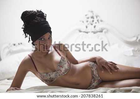 Beautiful model lying on a bed, wearing underwear and posing