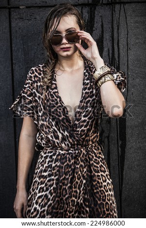 Beautiful blonde woman wearing sunglasses and a leopard-skin dress