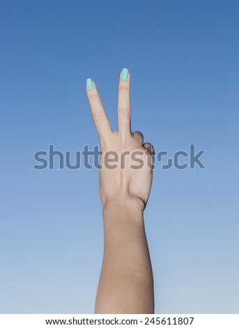 Female beautiful hand up in the sky making victory gesture