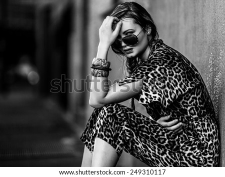 Weak woman sitting in the city black and white