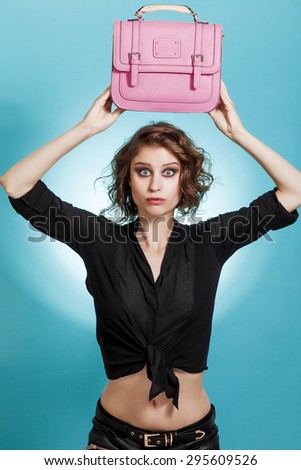 Beautiful girl portrait holding a pink bag over the head