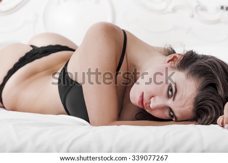 Sexy girl portrait wearing lingerie on bed and looking