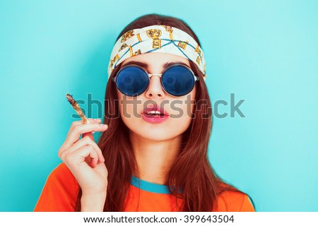 Hippy girl smoking weed and wearing sunglasses