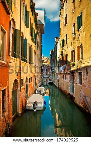VENICE, ITALY - 14 SEPTEMBER, 2013: Narrow canal with boat in Venice, Italy. The city in its entirety is listed as a World Heritage Site, along with its lagoon.