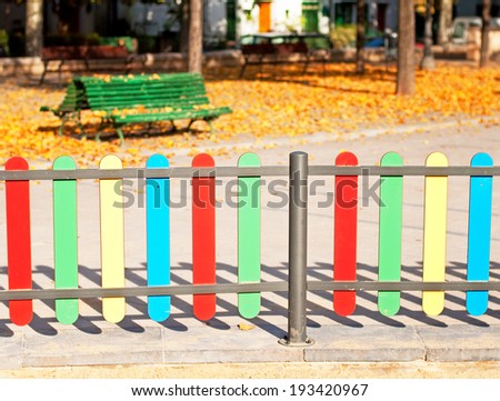 Colourful rows of painted wood on a playground fence
