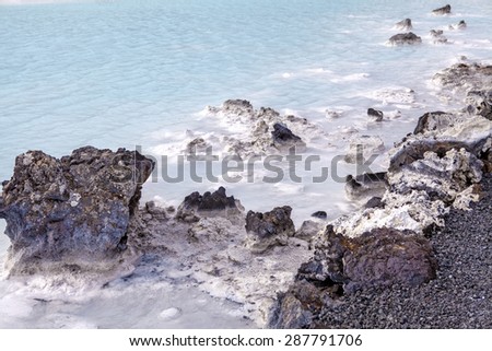 Rocks and warm waters rich in minerals like silica and sulfur in the Blue Lagoon near Reykjavik, Iceland.