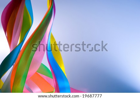 Color tapes on a blue background. A holiday of spring, a symbol of a carnival