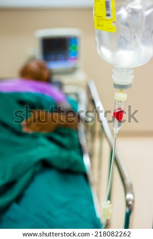 Closeup of infusion bottle with patient