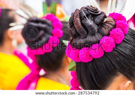Thai woman with hair bun and flower