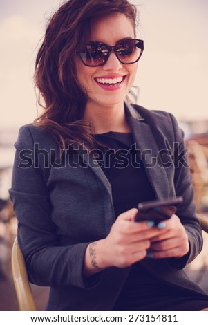 Young woman at cafe, text messaging