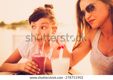 Worried and tired mother drinking juice with her daughter at cafe. Leave your work problems at work, don\'t affect your child with them