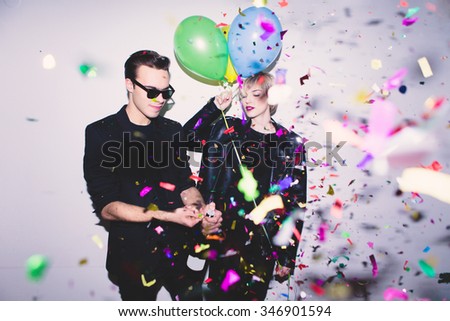 New Year\'s Party. Girl and boy posing in front of white wall with balloons