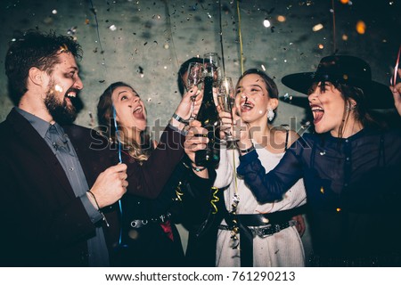 Group of happy friends drinking champagne and celebrating New Year. New year party. Birthday party