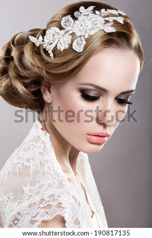 Portrait of a beautiful blonde woman in a wedding dress in the image of the bride. Picture taken in the studio on a blue background
