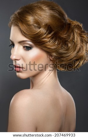 Beautiful girl with perfect skin and evening makeup. Portrait shot in the studio on a black background.