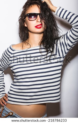 Beautiful girl in glasses with red lips and wet hair. Picture taken in the studio on a white background.
