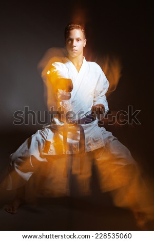 A young boy in a sports kimono in the image judo. Picture taken in a studio with a mixed light.