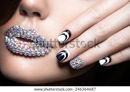 Beautiful girl with bright nails and lips of crystals, long eyelashes and curls. Beauty face. Picture taken in a studio.