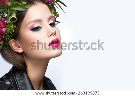 Beautiful girl with a lot of flowers in their hair and bright pink make-up. Spring image. Beauty face. Picture taken in the studio on a white background.