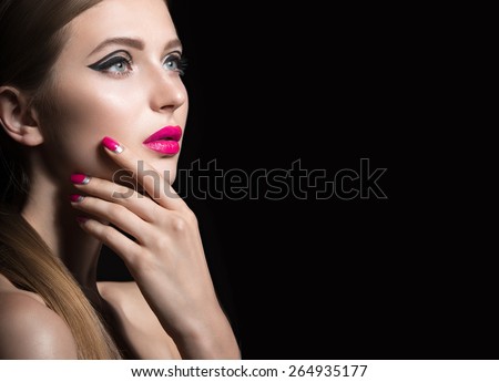 Beautiful girl with unusual black arrows on eyes and pink lips and nails. Beauty face. Picture taken in the studio on a black background.