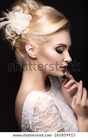 Portrait of a beautiful woman in the image of the bride with flowers in her hair. Picture taken in the studio on a grey background. Beauty face