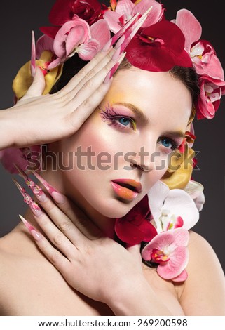 Beautiful woman with long nails, perfect skin, hair of orchids. Portrait shot in the studio.