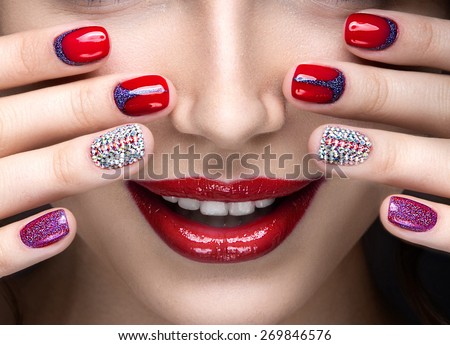 Beautiful girl with a bright evening make-up and  manicure with rhinestones. Nail design. Beauty face. Picture taken in the studio on a black background.