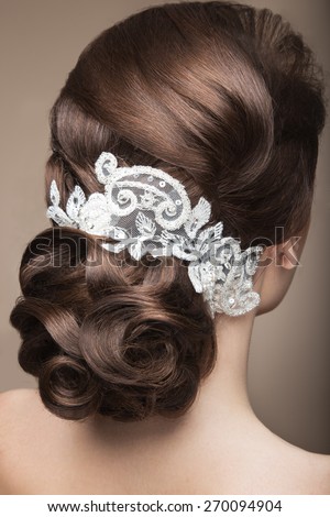 Portrait of a beautiful woman in the image of the bride with lace in her hair. Picture taken in the studio on a grey background. Beauty face.Hairstyle back view