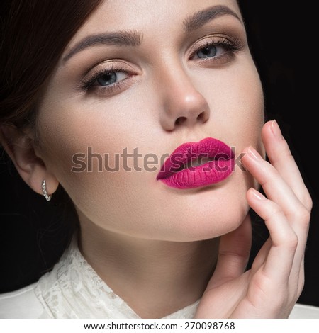 Beautiful girl with pink lips in white clothes in the form of retro. Beauty face. Picture taken in the studio on a black background.