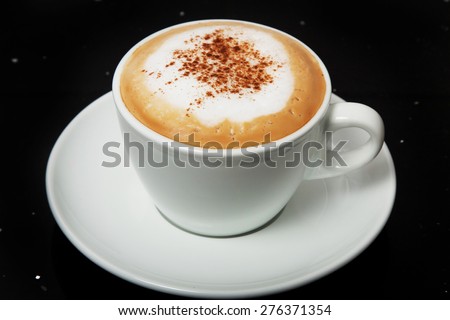 Cappuccino with cinnamon in a white cup.