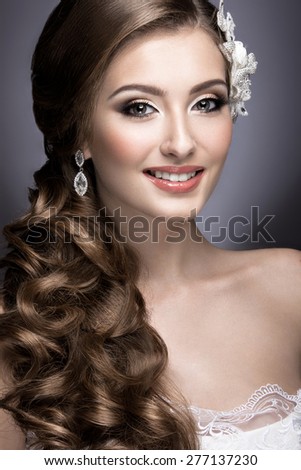 Portrait of a beautiful woman in the image of the bride with flowers in her hair. Picture taken in the studio on a black background. Beauty face