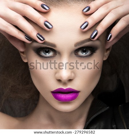 Beautiful girl in leather jacket with bright makeup and manicure \