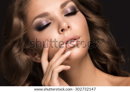 Beautiful woman with evening make-up and long straight hair . Smoky eyes. Fashion photo. Picture taken in the studio on a black background.