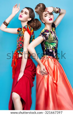 Beautiful fashionable women an unusual hairstyle in bright clothes and colorful accessories. Cuban style. Picture taken in the studio on a bright background.