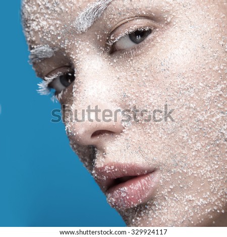 Portrait of girl with pale skin and sugar snow on her face. Creative art beauty fashion.