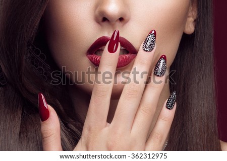 Pretty girl with unusual hairstyle, bright makeup, red lips and manicure design. Beauty face. Art nails. Studio portrait