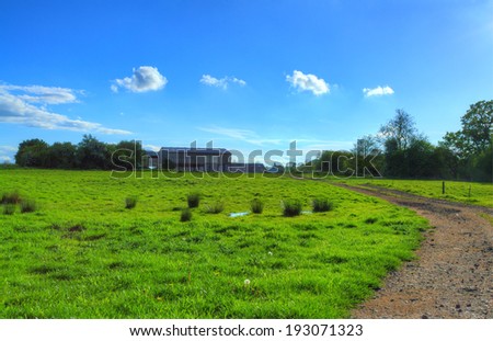 Dirt Track Through Field Leading up to Farm on Sunny Afternoon (HDR)