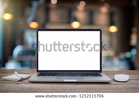 Desk Laptop with blank screen on table of coffee shop blur background with bokeh