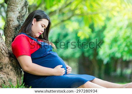 pregnant, maternity and new family concept - pregnant woman  outdoors