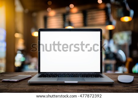 Laptop with blank screen on table of a cafe on Halloween.