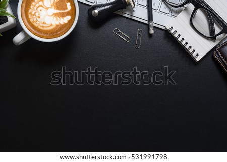 Cup of coffee, top view at the studio,Office leather desk table with coffee and supplies. Top view with copy space