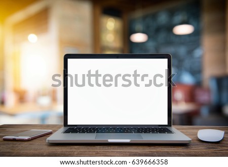 Laptop with blank screen on table of coffee shop blur background with bokeh.