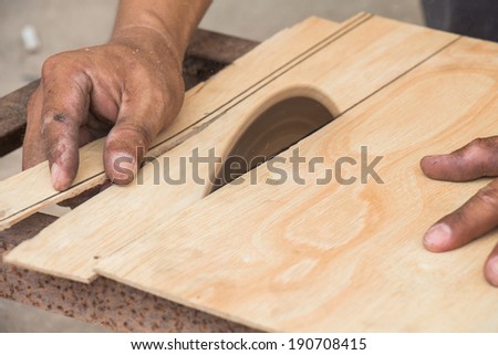 Carpenter using electrical saw for cutting wood