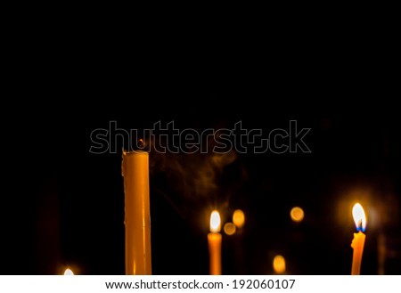 Yellow candle on the background and smoke
