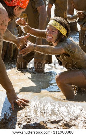 BOISE, IDAHO/USA - AUGUST 25:Unidentified woman is helped up out of the mud during the dirty dash.  The Dirty dash is a 10k run through obstacles and mud on August 25, 2012 in Boise, Idaho