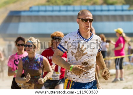 BOISE, IDAHO/USA - AUGUST 25:Crowd runs during the Dirty Dash covered in mud. The Dirty dash is a 10k run through obstacles and mud on August 25, 2012 in Boise, Idaho