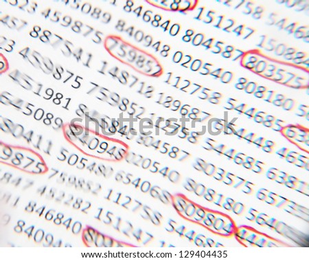 Image of numbers with some circled in red taken through a lens that distorted their image as though the numbers are trying to change.